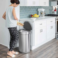 45L semi-round sensor bin - brushed finish - lifestyle woman scraping off food in kitchen