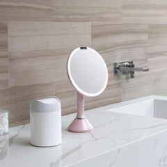 sensor mirror with touch-control brightness and dual light setting - pink finish - lifestyle in bedroom image
